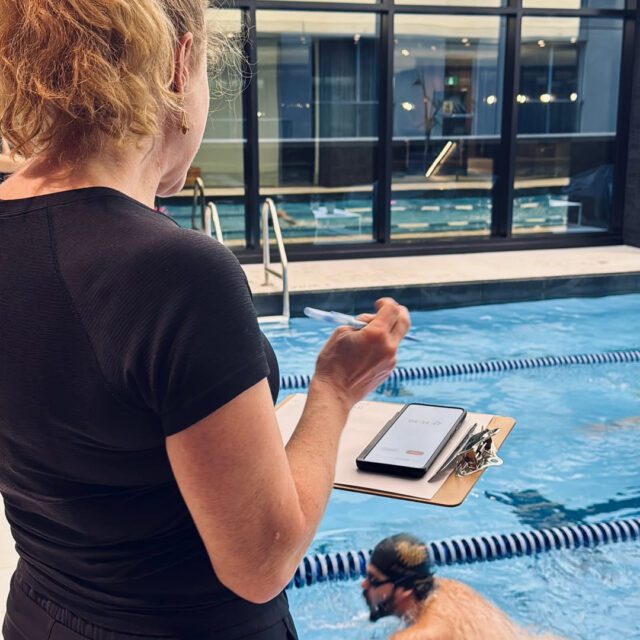 Entraîneuse observant un nageur dans la piscine intérieure du club sportif MAA au centre-ville de Montréal.