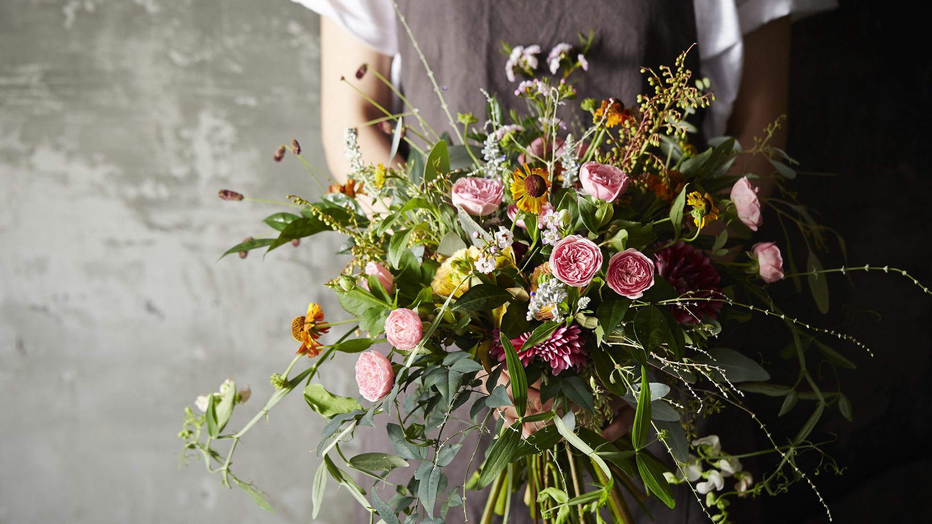 Bouquet de fleurs fraîches aux tons rosés et naturels, composé de fleurs de saison et de feuillages délicats.