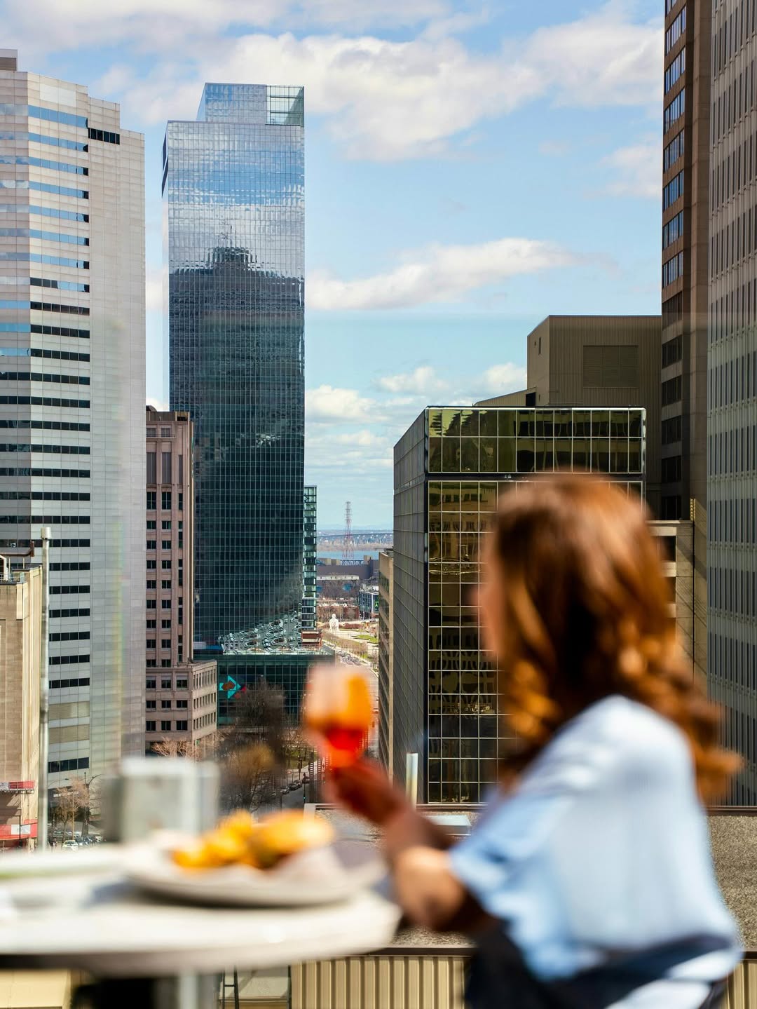 Femme buvant un cocktail en regardant au loin, sur la terrasse