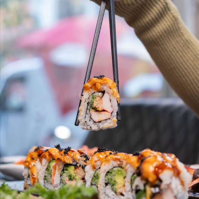 Baguettes qui tiennent un sushi au sushiuma  au centre-ville de Montréal