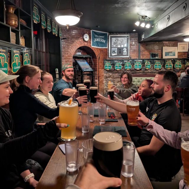 Groupe d’amis au pub Hurley’s avec pintes de Guinness