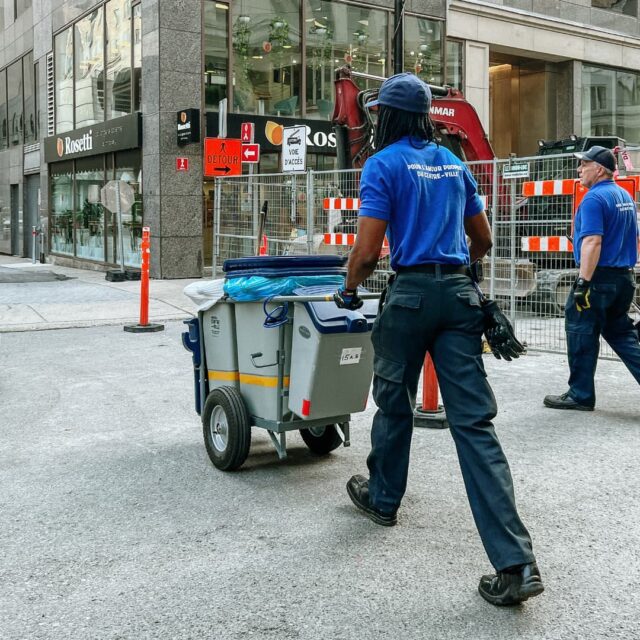 Un brigadier poussant son chariot sur la rue Sainte-Catherine Ouest, autour du chantier