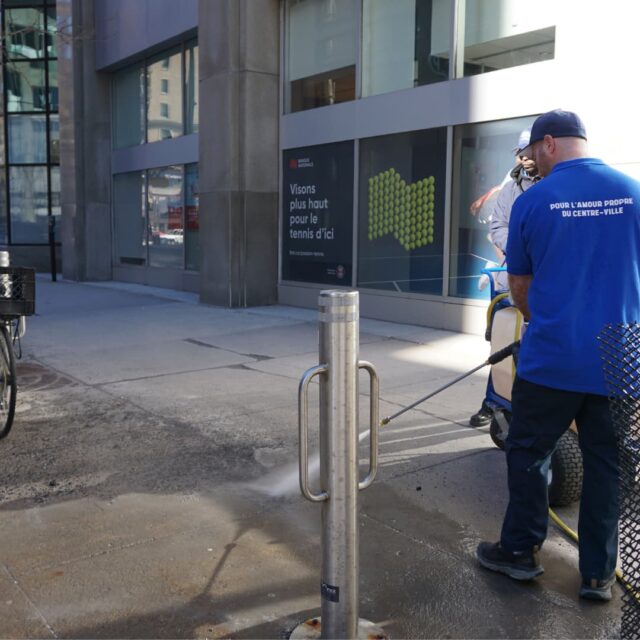 Un brigadier nettoyant le trottoir avec sa machine à pression