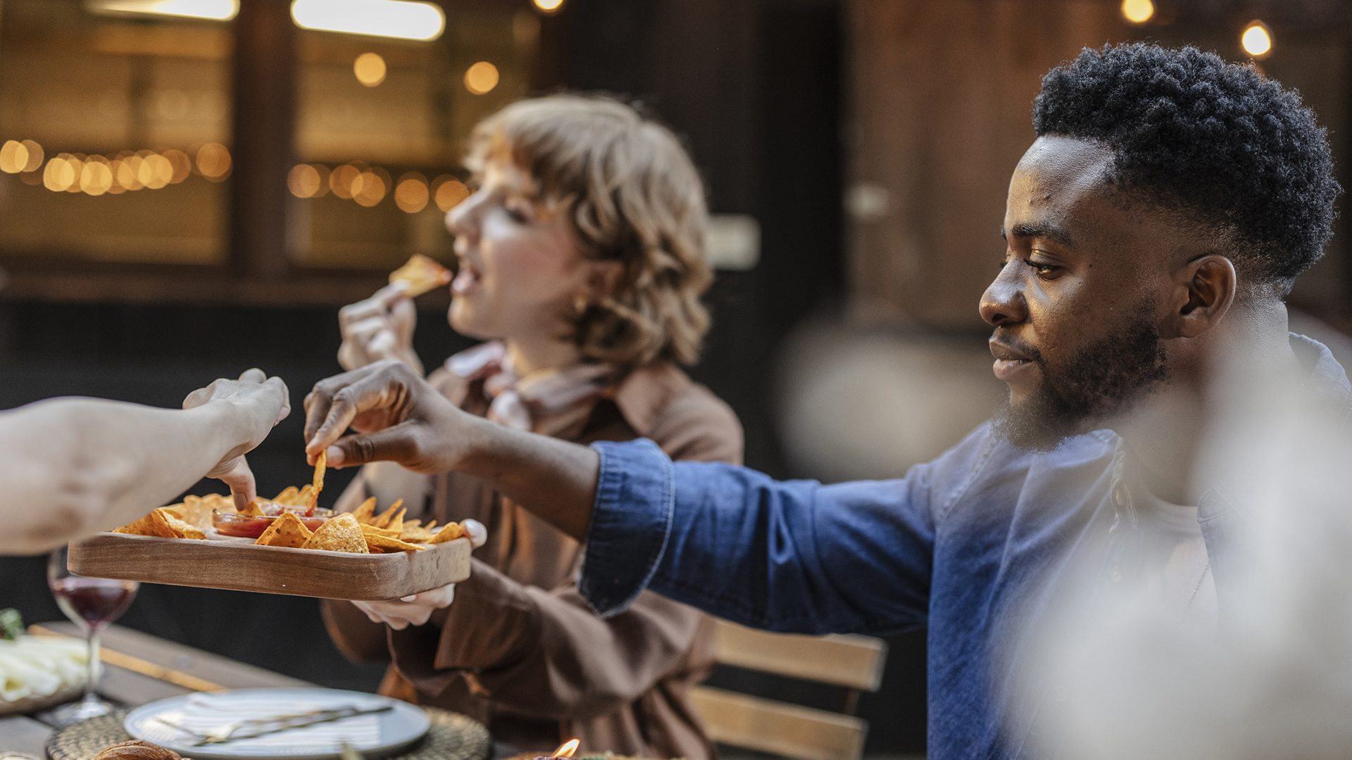 Amis partageant des nachos sur une terrasse conviviale au centre-ville de Montréal.