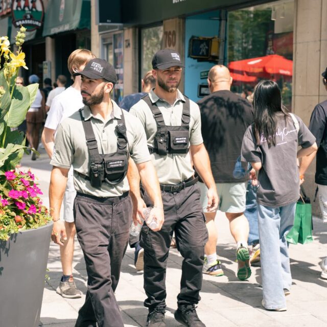 2 agents de la brigade de sécurité de proximité marchent sur la rue Sainte-Catherine Ouest, parmi les visiteurs