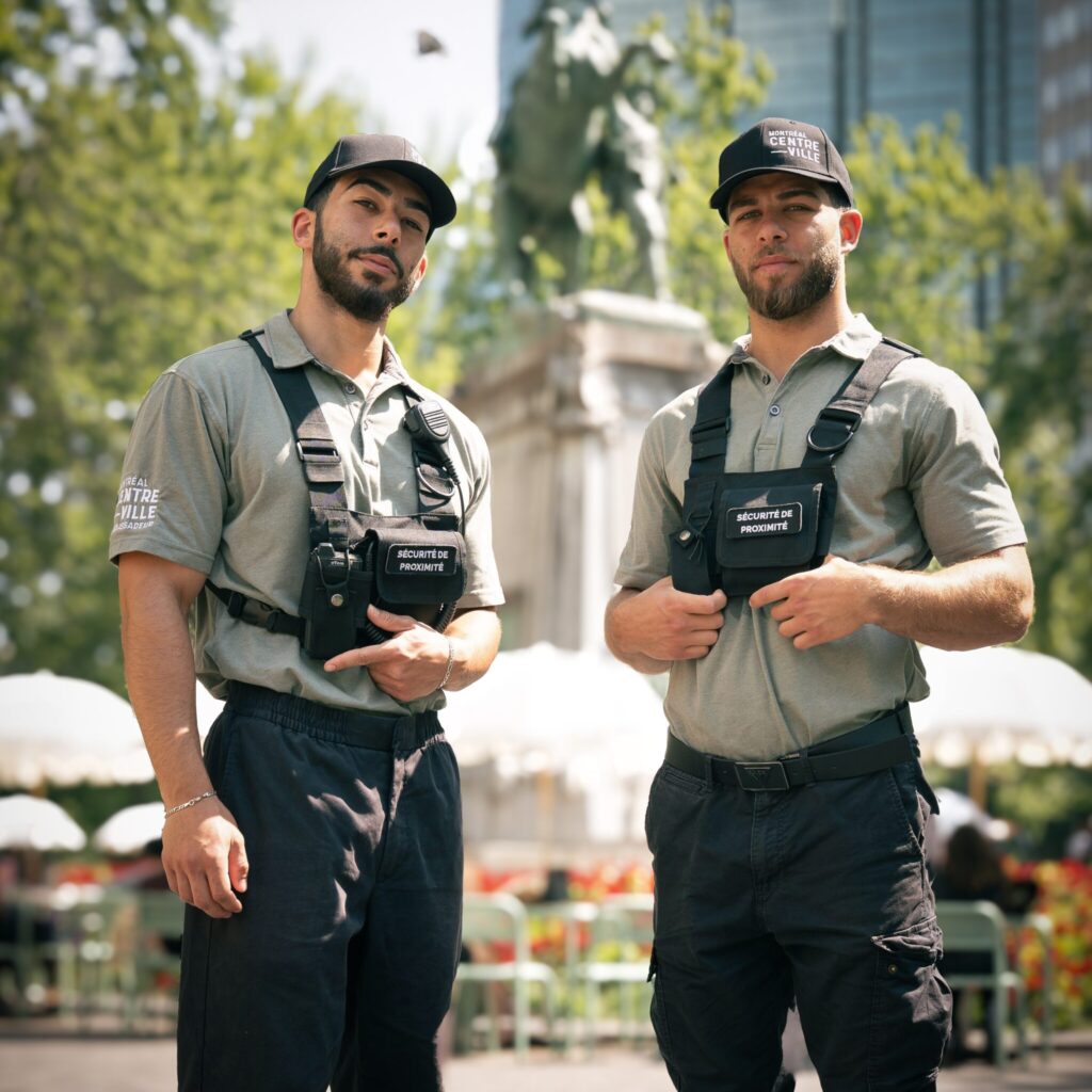 Deux membres de la brigade de sécurité de Montréal centre-ville regardent la caméra.