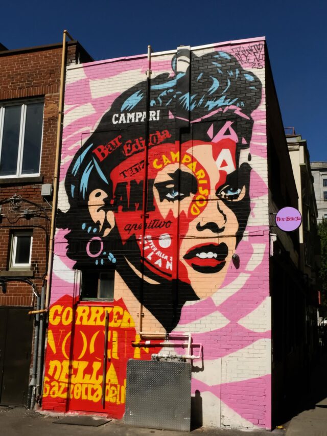 Une murale représentant le visage d'une femme sur le côté d'un restaurant.