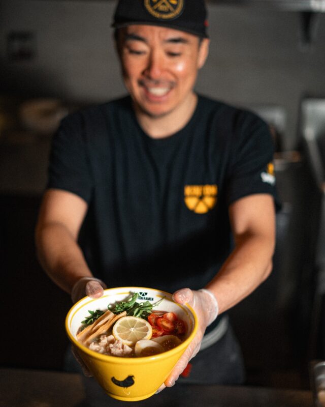 Un homme tient un bol de ramen.