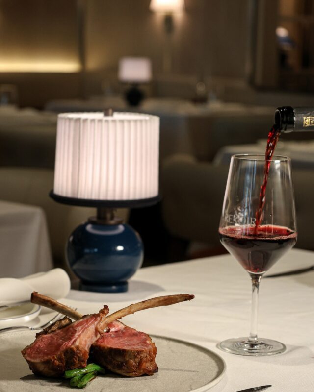 Une pièce de viande et un verre de vin sur une table