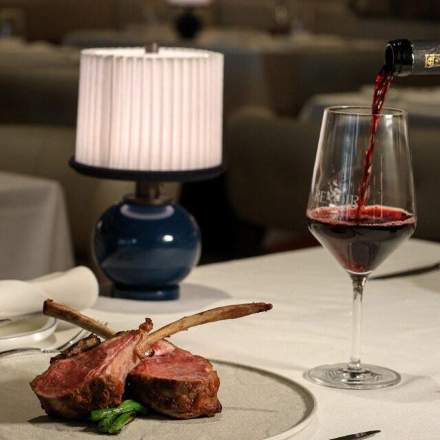 Une pièce de viande et un verre de vin sur une table