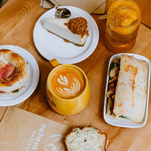 Sélection de café, latte art, sandwich et dessert servis chez Columbus Café & Co au centre-ville.