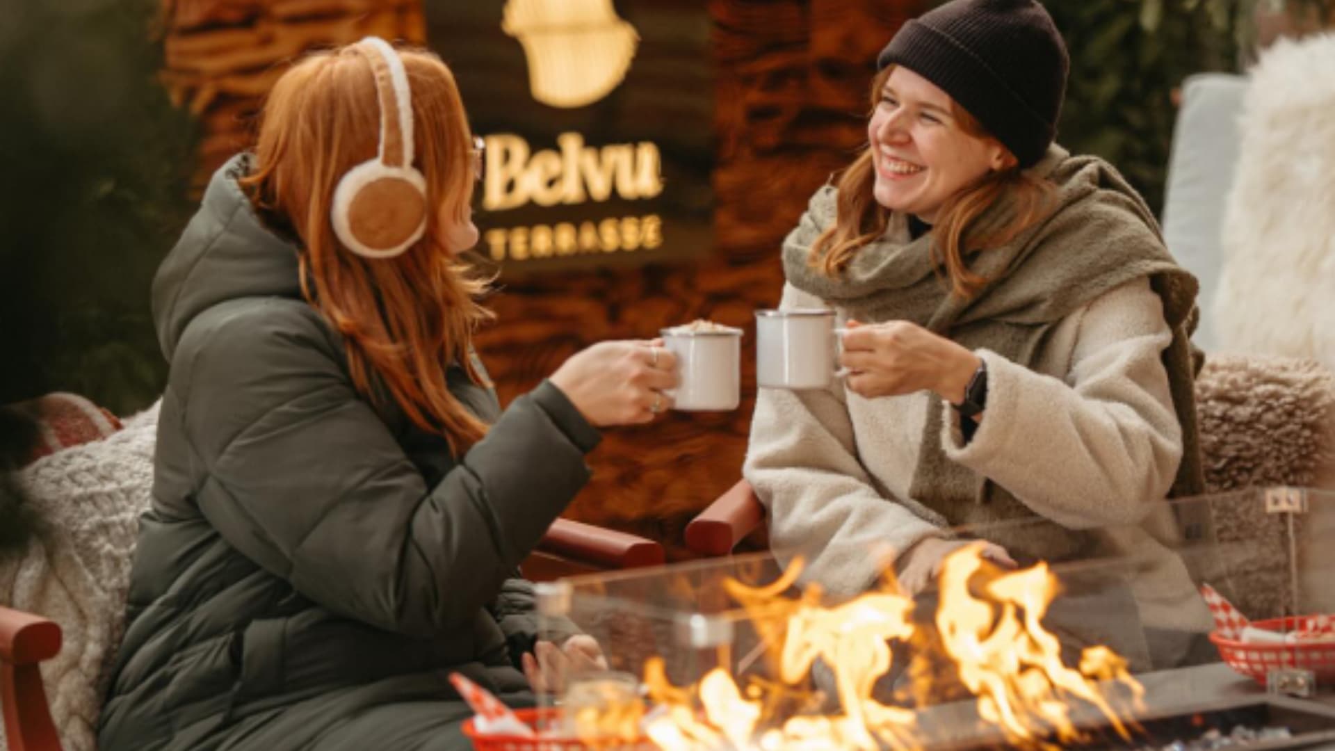 Deux jeunes femmes savourant une boisson chaude sur une terrasse en hiver