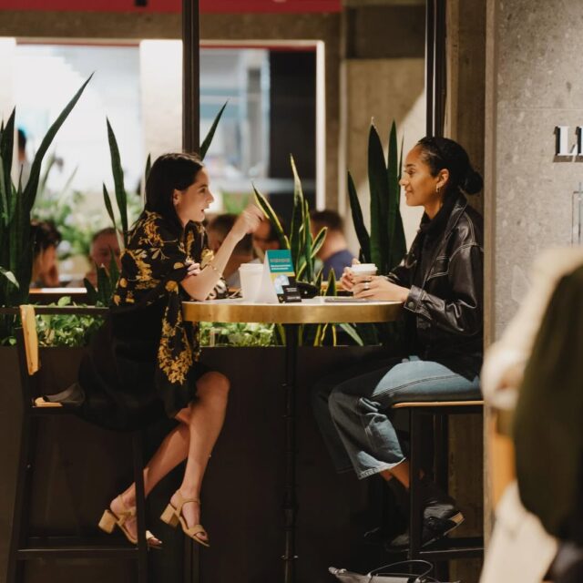 Deux personnes en discussion autour d’un café au Cathcart Montréal