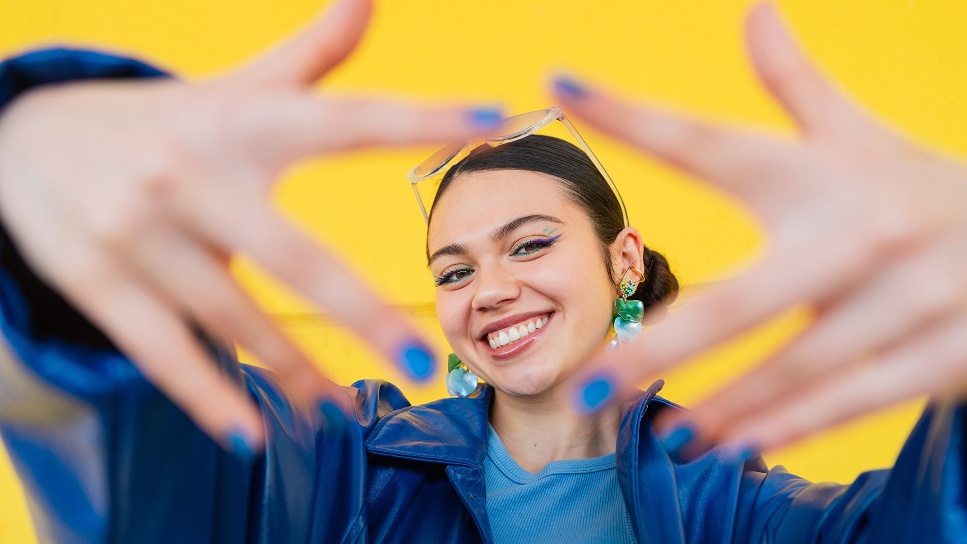 Jeune femme souriante sur fond jaune illustrant les nouveautés au centre-ville de Montréal